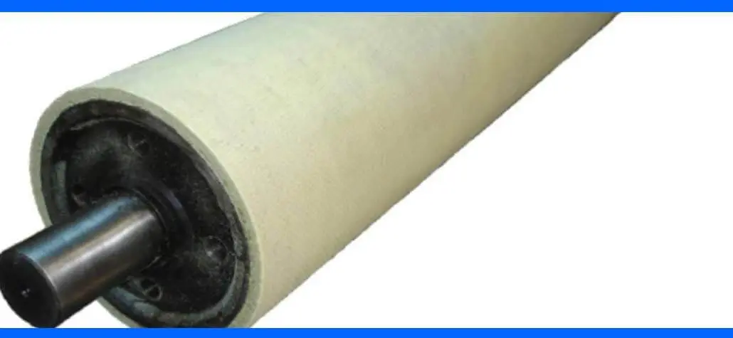 A close-up of a cylindrical industrial roller with a metal shaft and a textured, light-colored surface.