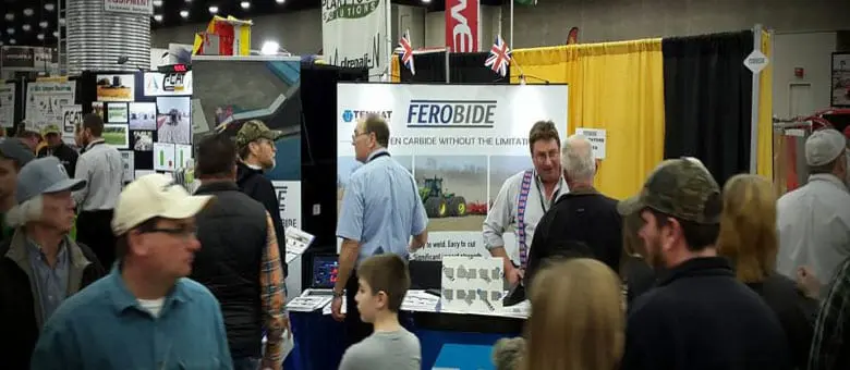 Crowd of people attending an indoor trade show with a Ferobide booth in the background.