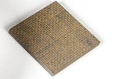 A square piece of brown composite material with a textured, woven pattern on its surface.