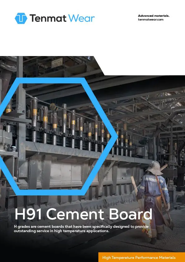 Worker observing industrial cement board machinery in a factory, with Tenmat Wear branding.