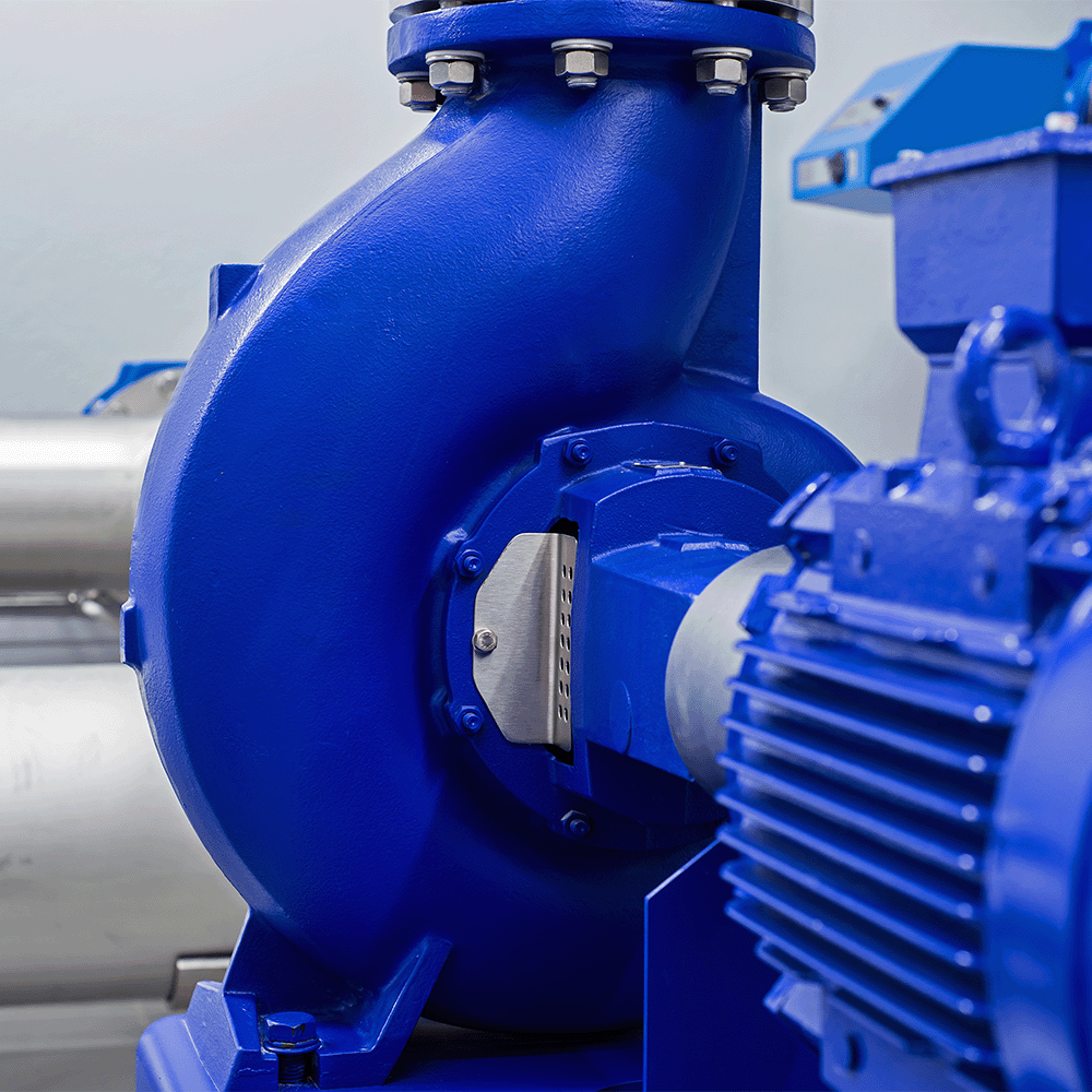 Close-up of a blue industrial pump and electric motor with metal pipes in the background.