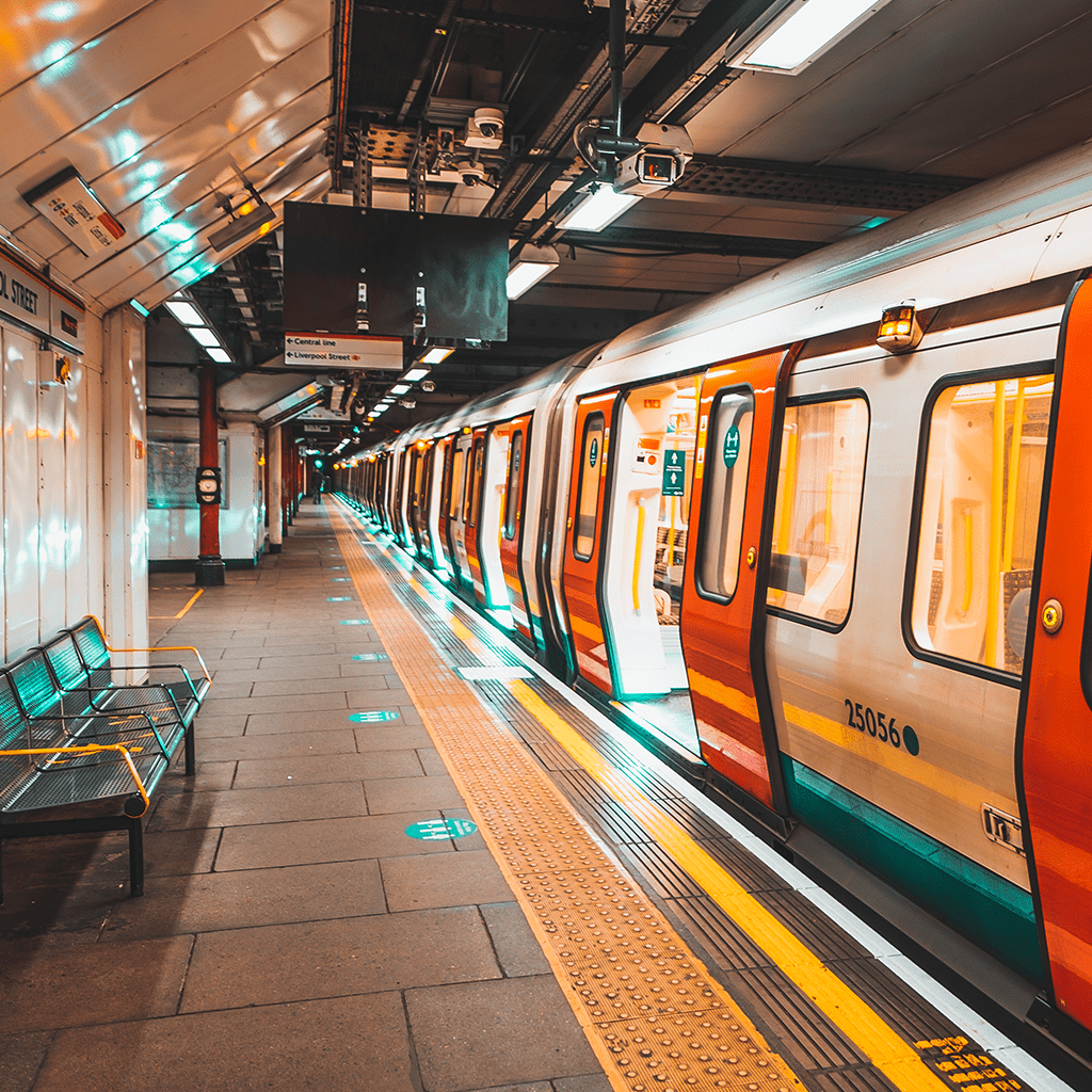 A modern subway train stopped at an empty, well-lit underground station platform.