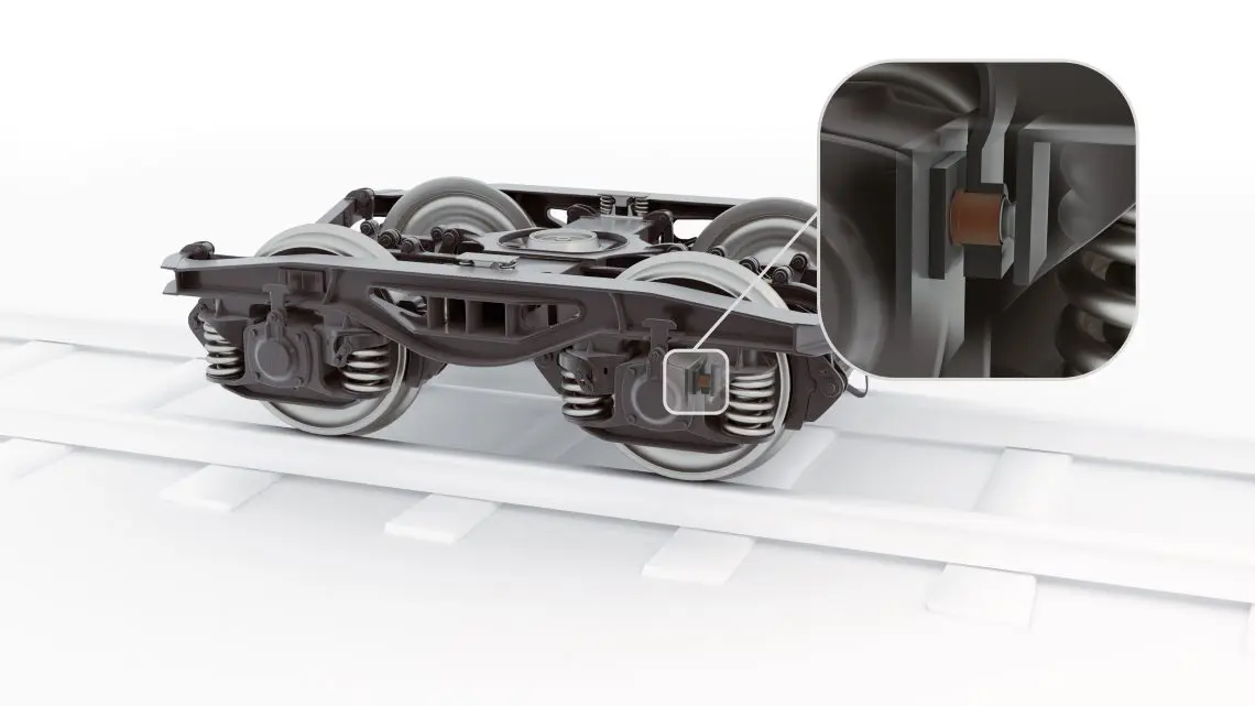 16-wp-friction-damper-bushes-rail-tds-in-situ1 A train wheel assembly on tracks with a zoomed-in view highlighting a specific component.