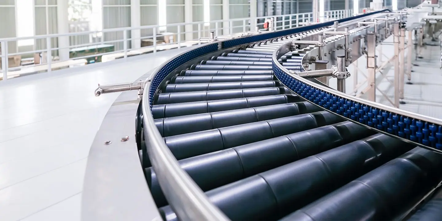 Curved industrial conveyor belt system in a bright, modern factory setting.