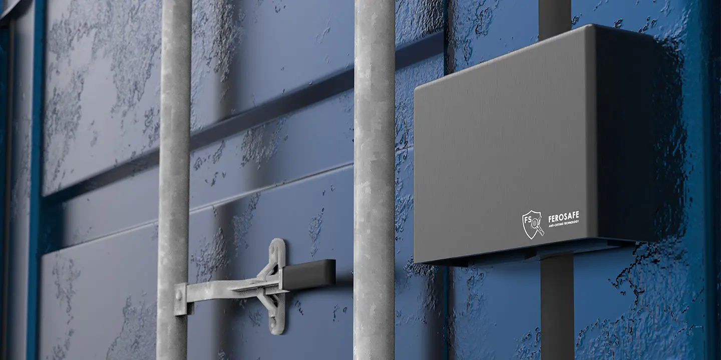 A black security device is attached to a blue metal shipping container door near its latch and handle.