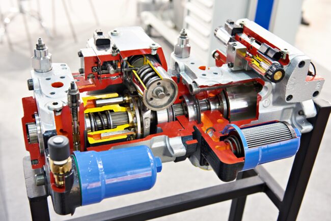 Adjustable,Axial,Piston,Pump,Of,Open,Contour,In,Section Cutaway view of an industrial hydraulic pump, showing internal gears, pistons, and components.