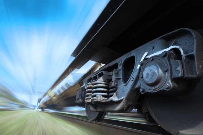 Jul 30 2021 Close-up of a moving train wheel and suspension system with a blurred background, suggesting high speed.