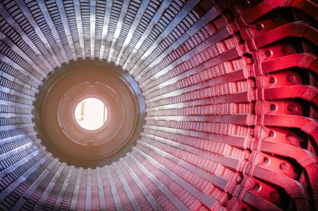 Stator,Generators,Of,A,Big,Electric,Motor,In,The,Coal Close-up view inside a large industrial motor or generator showing metallic fins and red components.