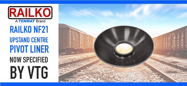 ralko-nf21-upstand-centre-pivot-liner-ucpl-rail-wear-parts Black pivot liner displayed with train tracks and railcars in the background; Railko NF21 product text on left.