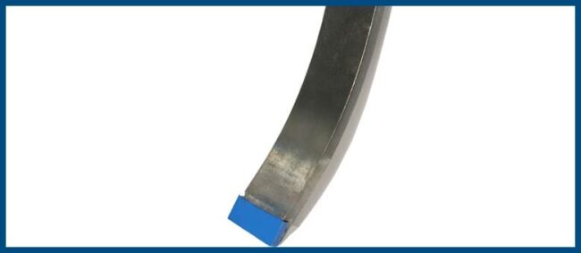 tenmat-develops-innovative-wear-material-to-revolutionise-cultivation A metal lathe tool with a blue-tipped cutting edge, shown against a white background with a blue border.