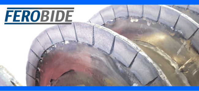 tenmat-ferobide-tiles-decanter-centrifuges Close-up of metal screw conveyor blades with protective Ferobide tiles; Ferobide logo at top left.