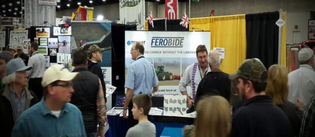 total-freedom-when-protecting-soil-engaging-tools-against-wear-with-ferobide Crowd of people attending an indoor trade show with a Ferobide booth in the background.
