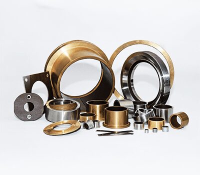 Assorted metal and brass machine parts and rings displayed on a white background.